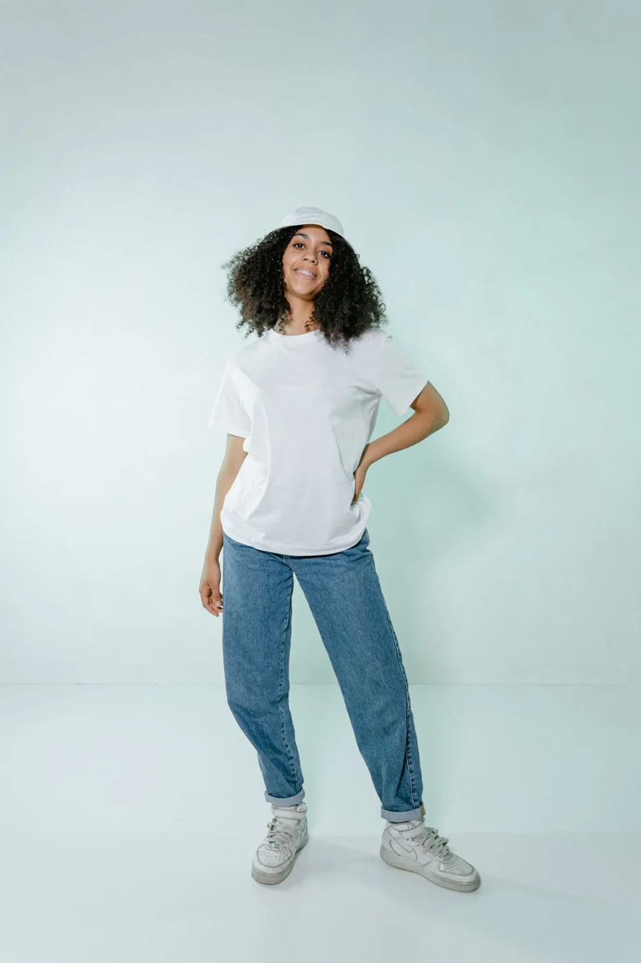 Schlichtes weißes T-Shirt mit blauer Jeans und Turnschuhen.