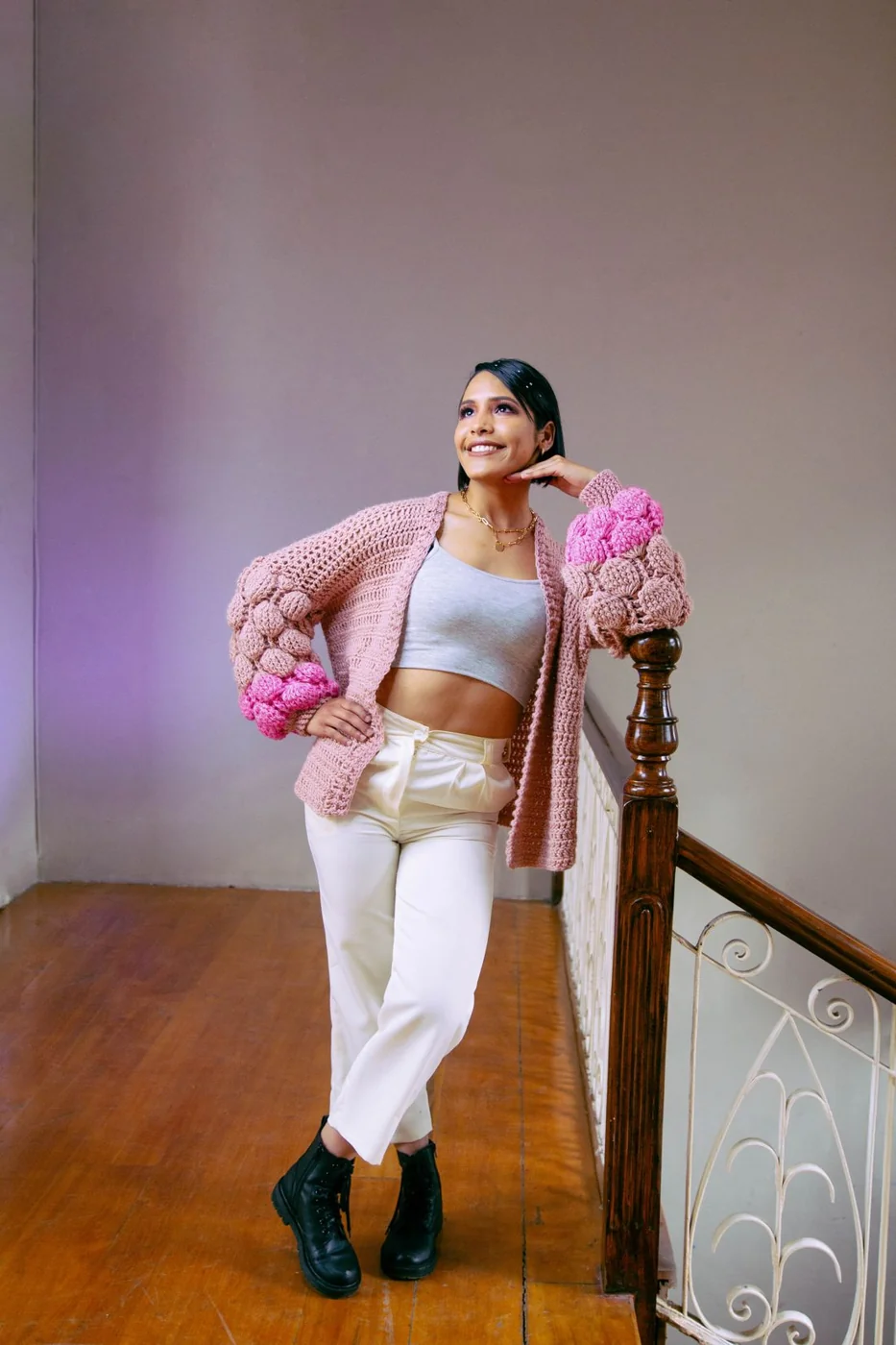 Offene rosa Strickjacke mit weißer Hose.