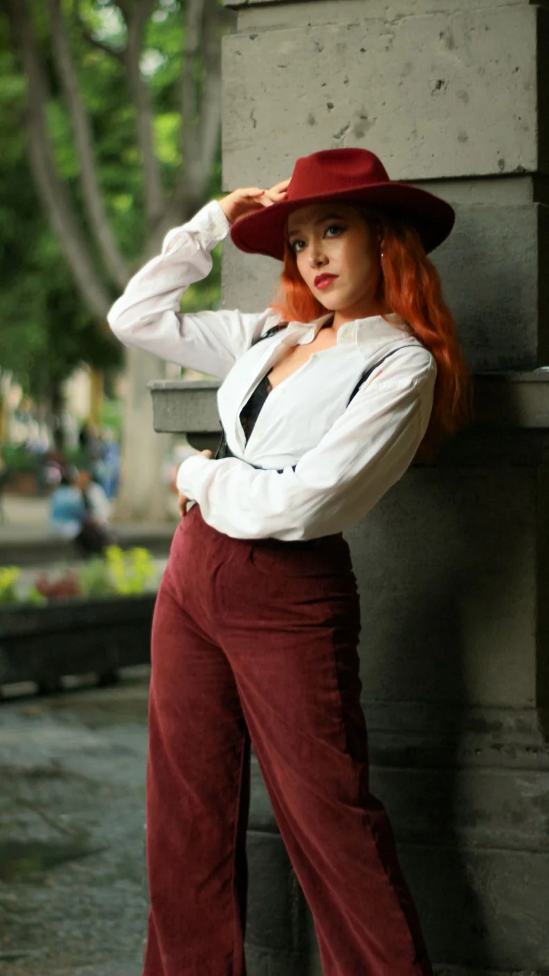 Dunkelrote Cordhose mit weißer Bluse und Weste.