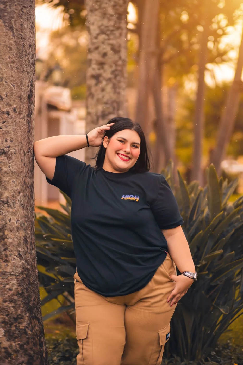 Beigefarbene Cargohose mit einem schwarzen T-Shirt.