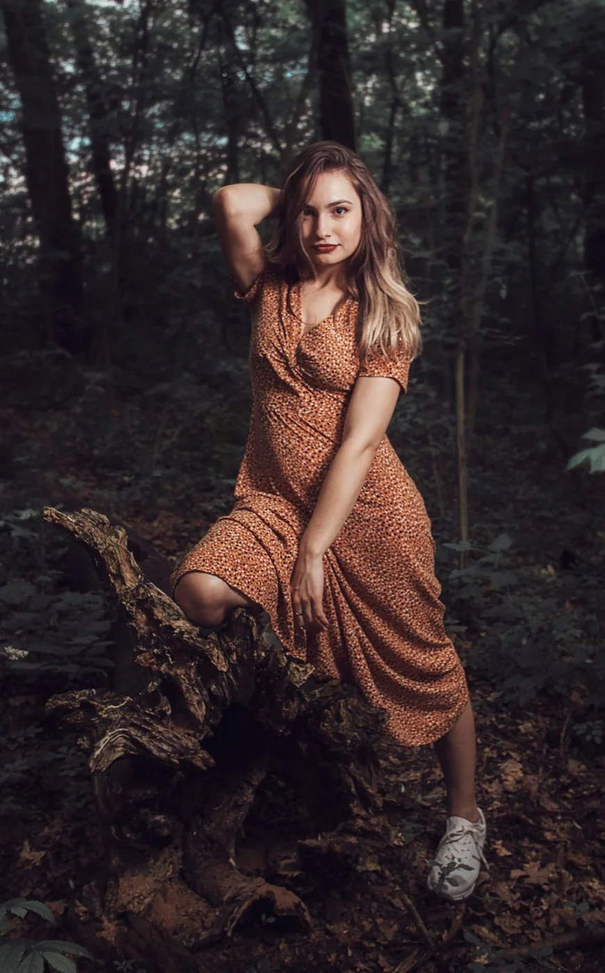 Gemustertes Kleid mit hellen Turnschuhen.