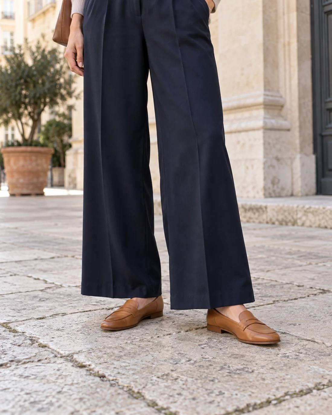 Weite dunkelblaue Hose mit flachen Loafern.