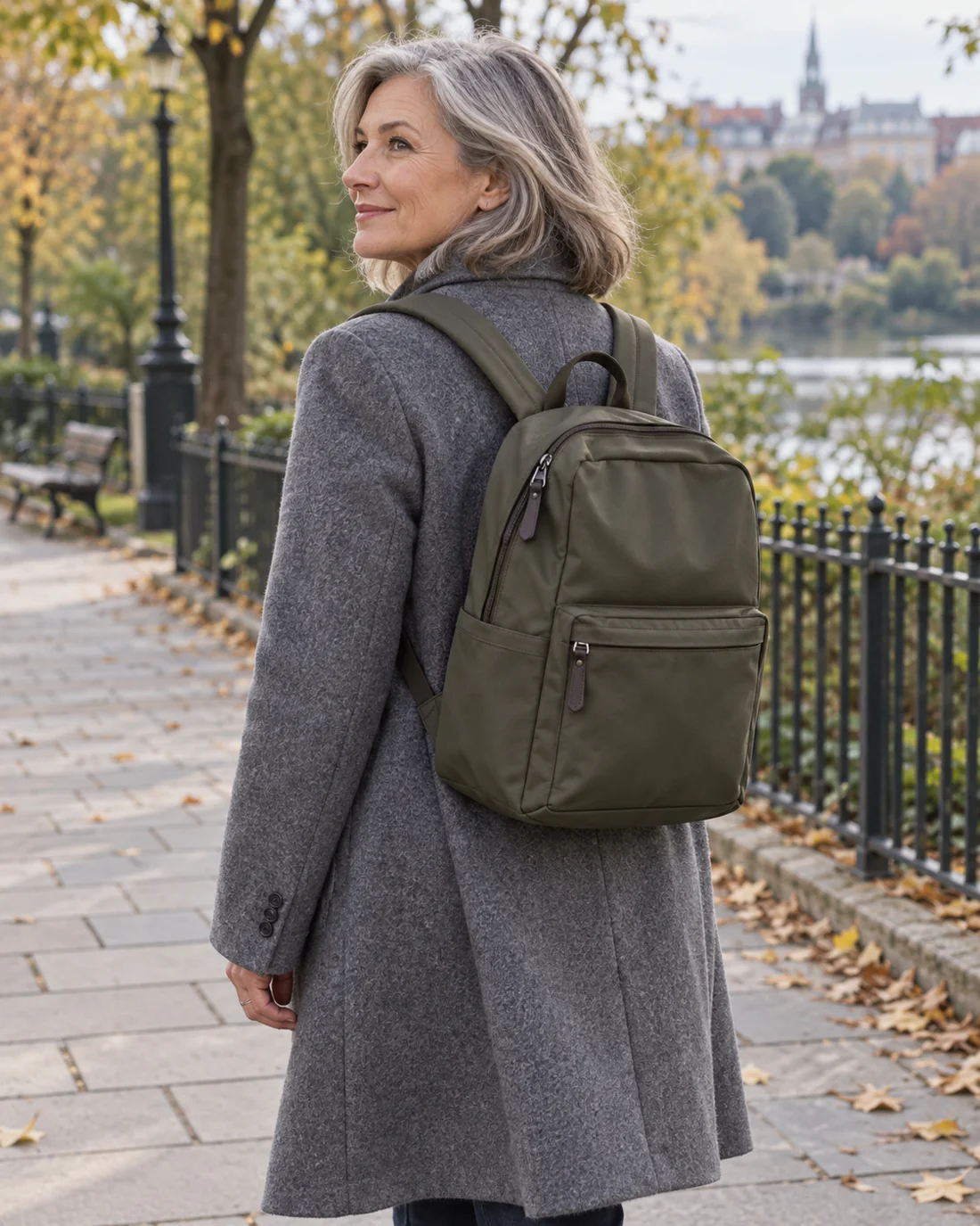 Olivgrüner Rucksack über einem grauen Wollmantel.