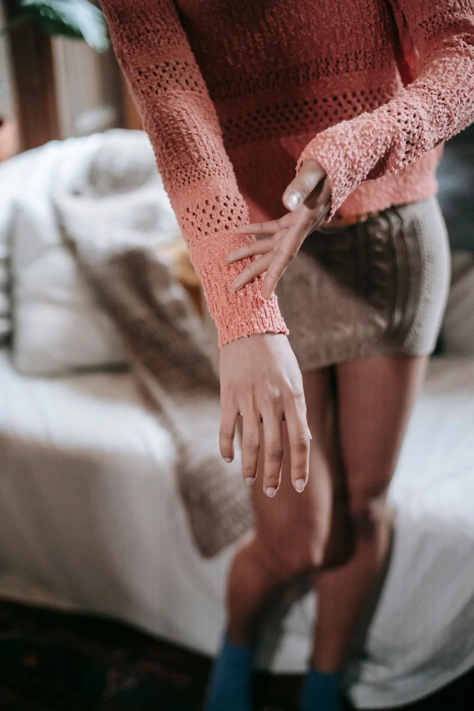Frau zeigt den Ärmelabschluss ihres Strickpullovers.
